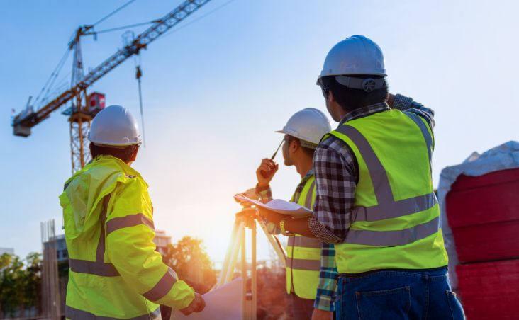 Baustellenlogistik-Arbeiter mit Warnwesten prüfen Projektstatus