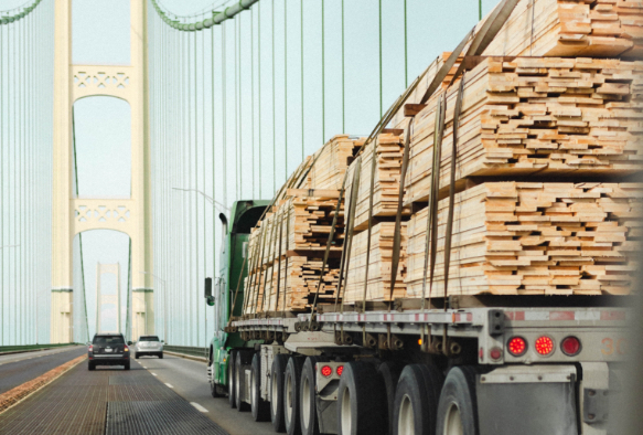 Verschiedene Holzstapel werden auf LKW transportiert
